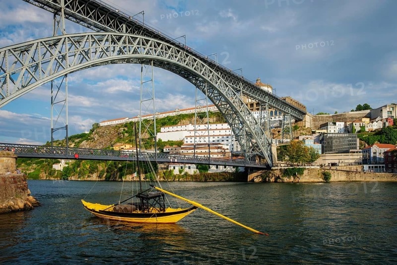 View of Vila Nova de Gaia city with Mosteiro da Serra do Pilar monastery and Dom Luis I bridge over Douro river with traditional boat with port wine barrels. Porto, Vila Nova de Gaia, Portugal