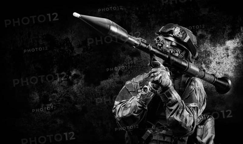 American soldier is aiming at an RPG sight against a dark background. The concept of military special operations.