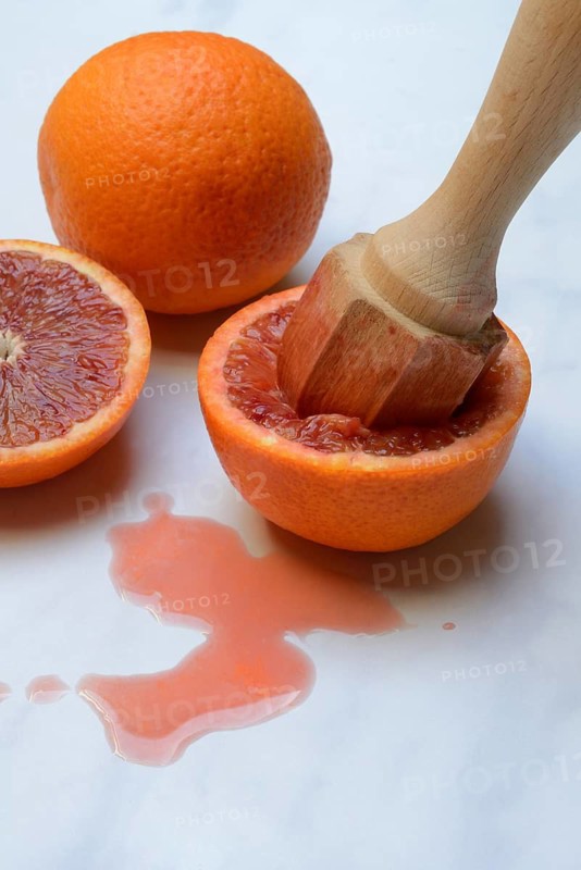 Halved blood orange with citrus squeezer, orange