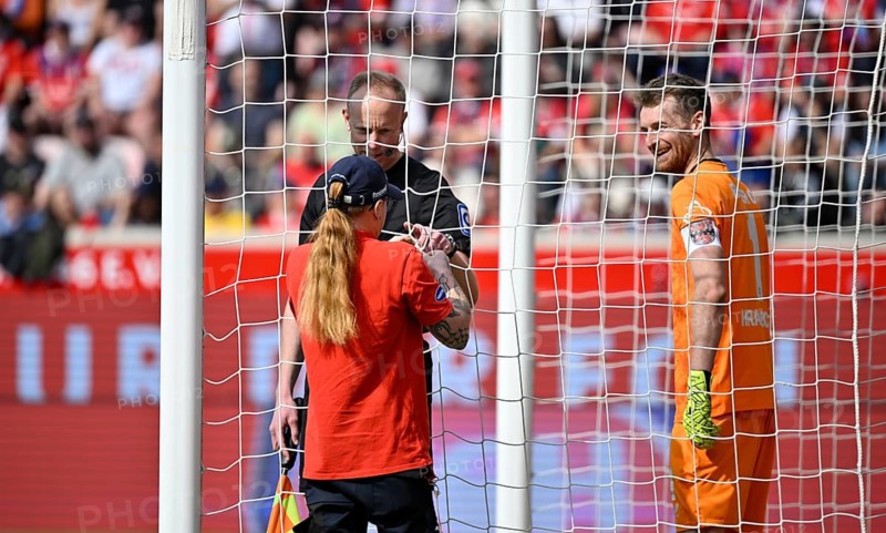 Goal net being mended, net being repaired, linesman, assistant referee, goalkeeper Lukas Hradecky Bayer 04 Leverkusen (01) smiles Voith-Arena, Heidenheim, Baden-Württemberg, Germany