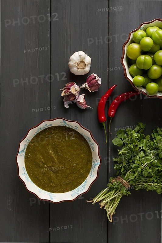 Tkemali sauce, traditional Georgian cuisine, green cherry plum, with ingredients for sauce, cilantro, mint, hot pepper, garlic, on a wooden table, close-up, rustic, food background, no people, selective focus, sauce, green sauce, tkemali, georgian cuisine, homemade