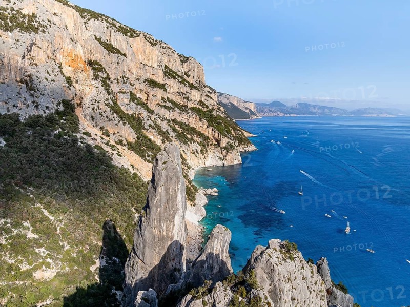 Picturesque rocky coast, cliffs with L'Aguglia pinnacle, blue sea and Cala Goloritzé beach, aerial view, Golfo di Orosei, Baunei, Sardinia, Italy