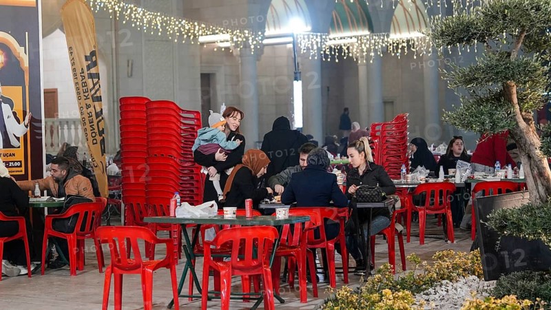 Muslim families and individuals gather at outdoor tables for a mass community Iftar meal under festive Ramadan lights in Gaziantep, Turkey on March 11, 2026, Gaziantep, Turkey