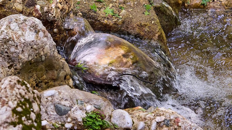 Water flowing over smooth stones in a natural stream, Butterfly Valley, Butterfly Valley, Rhodes, Dodecanese, Greek Islands, Greece