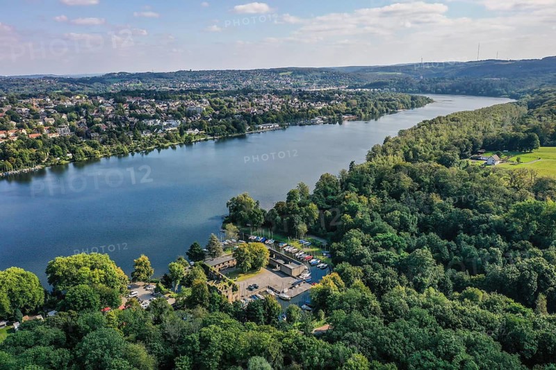 Essen, Ruhr area, North Rhine-Westphalia, Germany - Lake Baldeney, Haus Scheppen in front. Haus Scheppen is a former noble feudal estate of Werden Abbey in the Fischlaken district of Essen. Today, the forecourt is used as a bikers' meeting place and the moats are used as boat moorings