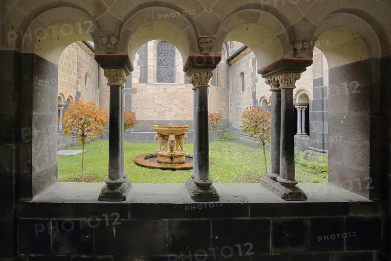 View through pillars and archways to the courtyard with lion fountain, autumn colors, Maria Laach, Benedictine Abbey, Eifel, Rhineland-Palatinate, Germany