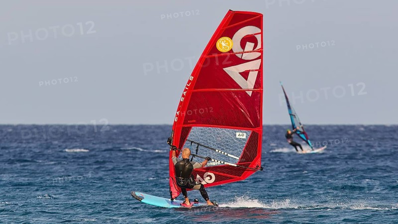 A windsurfer with a red sail surfs over the blue sea, windsurfer, Meltemi windsurfing spot, Devils Bay, Paralia Vatha, Vatha Beach, south-east coast, Karpathos, Dodecanese, Greek Islands, Greece