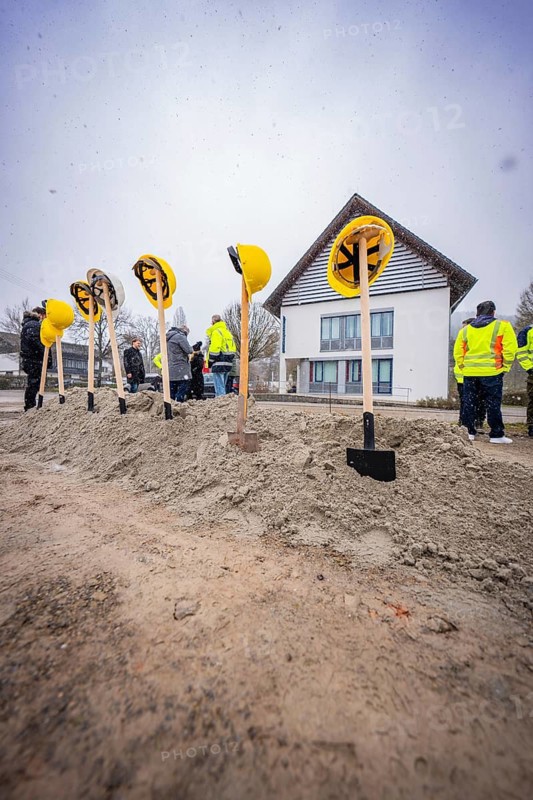 Spade with helmets in a pile of sand, several people and a building in the background, fiberglass groundbreaking, Glatten, Freudenstadt district, Germany