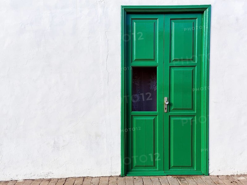 Typical green painted wooden door, white house wall, facade detail, text free space, Teguise, Lanzarote, Spain