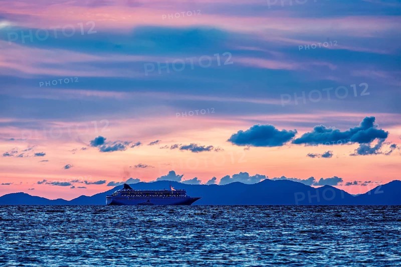 Vacation cruise background, sunset sea with cruise ship. Andaman sea, Thailand