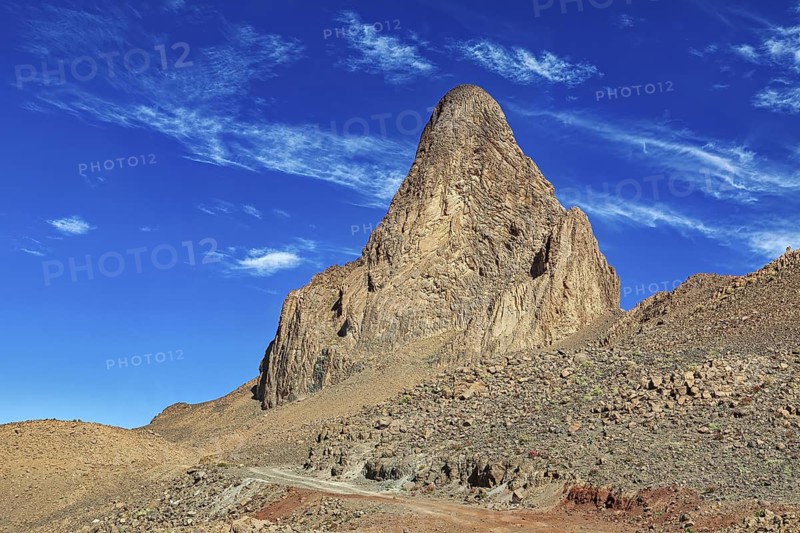 Dramatic rock in front of a deep blue, cloudy sky, The landscape of the Ahaggar Mountains in the Sahara in Algeria