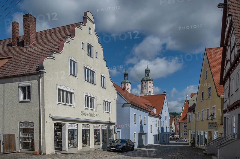 Historic houses, in the background the towers of the Catholic parish church of St Emmeram, Wemding, Swabia, Bavaria, Germany