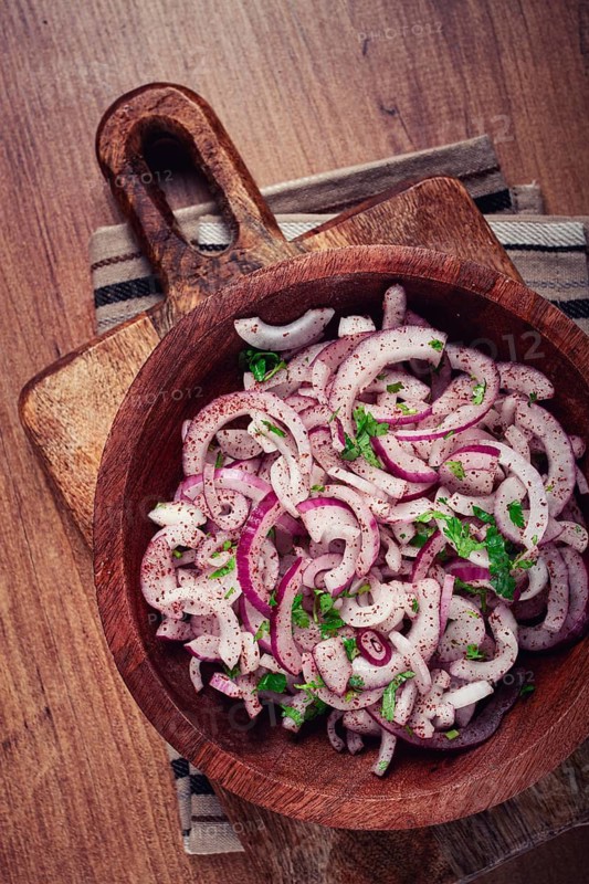 Chopped red onion, with sumac and herbs, in a bowl, pickled Spanish onion, close-up, top view