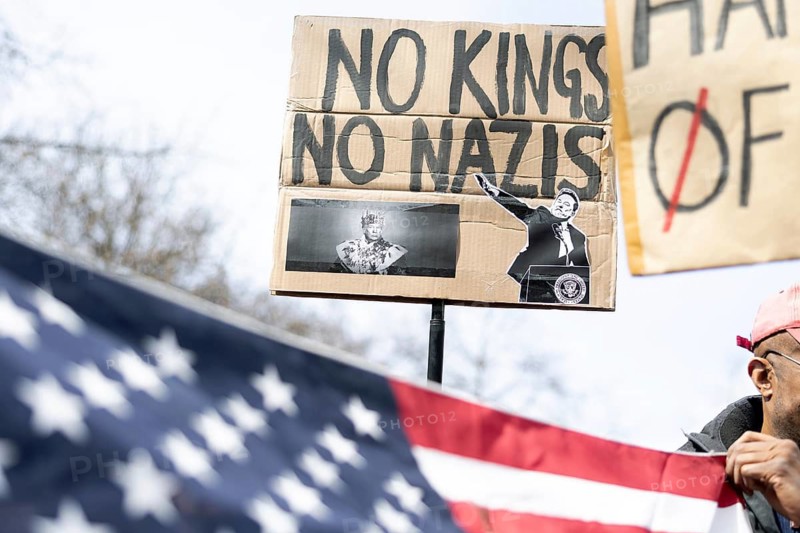 Berlin, Germany - 5 April 2025: A demonstrator holds a sign with the inscription No Kings No Nazis and with the image of Donald Trump as a king and Elon Musk with his right arm outstretched and protests with other demonstrators in front of the US Embassy in Berlin against the policies of US President Donald Trump and his advisor, Tesla owner Elon Musk under the slogan Hands Off