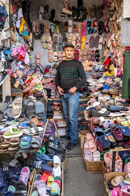 Man selling shoes, many different shoes, market stall at Osh bazaar, Bishkek, Kyrgyzstan