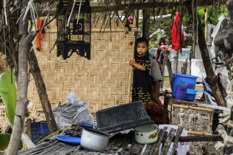Child in front of a hut in an Indonesian village, village, child, boy, curious, curiosity, childhood, carefree, lifestyle, village life, street scene, Asian, authentic, local, tradition, traditional, travel, tourism, culture, poverty, person, Sasak, indigenous, indigenous people, heritage, portrait, human, Sade village, Lombok, Indonesia