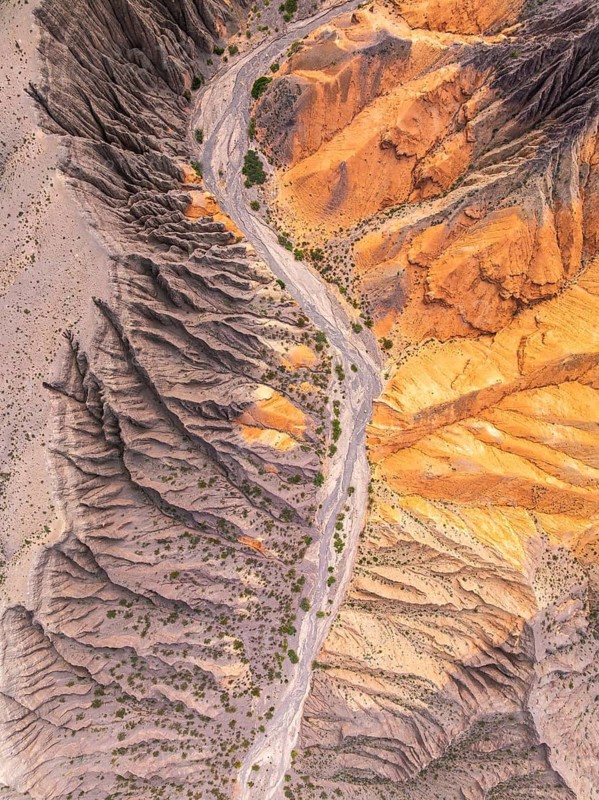 Stunning aerial view of the Hill of Seven Colors in Purmamarca, Argentina, showcasing vibrant layers of mineral rich terrain, creating a mesmerizing natural tapestry
