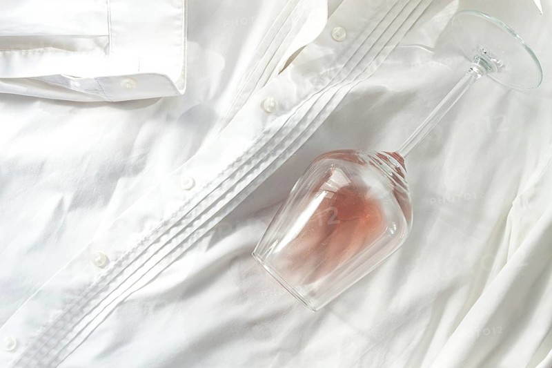 Glass, with pink wine, spilled on a white shirt, close-up, selective focus, no people, concept, top view