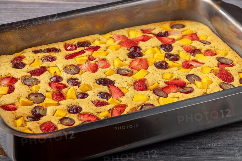 Freshly baked fruit cake in the shape of mango, strawberries and grapes