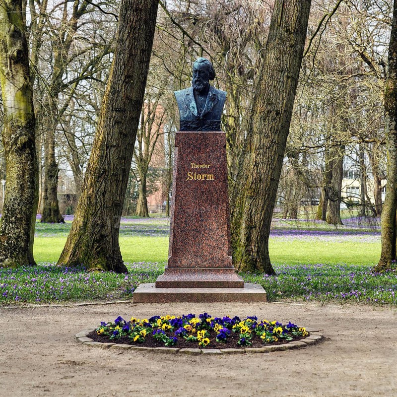 Monument to the writer Theodor Storm, bust by sculptor Adolf Brütt, crocus blossom, Husum Castle Park, Husum, North Frisia, Schleswig-Holstein, Germany