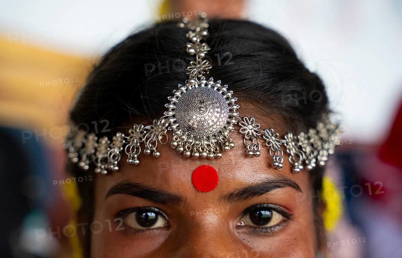 A girl from tea tribe community wearing traditional jewellery, wait to perform traditional Jhumur dance, on the eve of 'Jhumoir Binandini' event at the Sarusajai Stadium in Guwahati, India on February 23, 2025. Jhumur Dance is a traditional folk dance popular in Assam, West Bengal, Jharkhand, and Odisha, mainly performed by the Adivasi (Tea Tribe) community and other indigenous groups