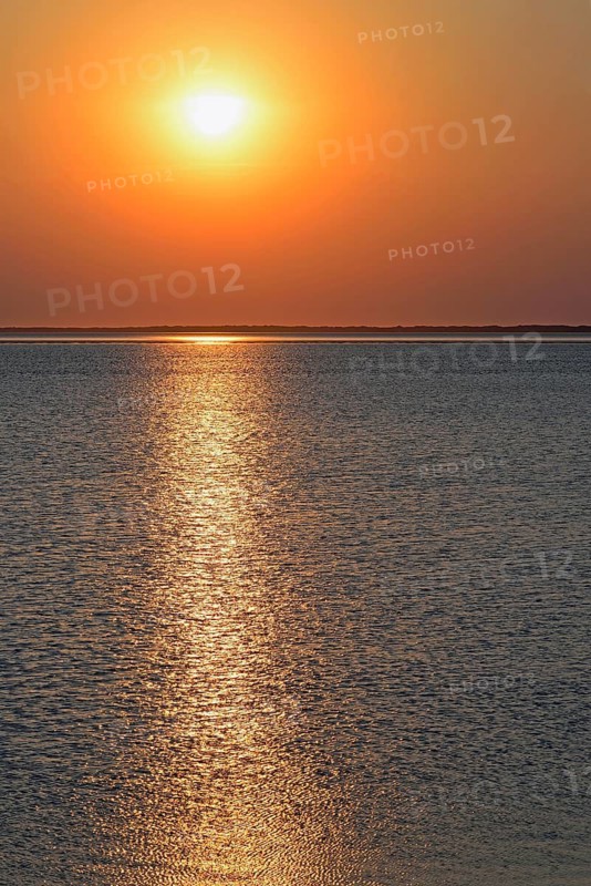 Sunset over the North Sea at low tide, the outline of the island of Juist on the horizon, Norddeich, Lower Saxony, Germany
