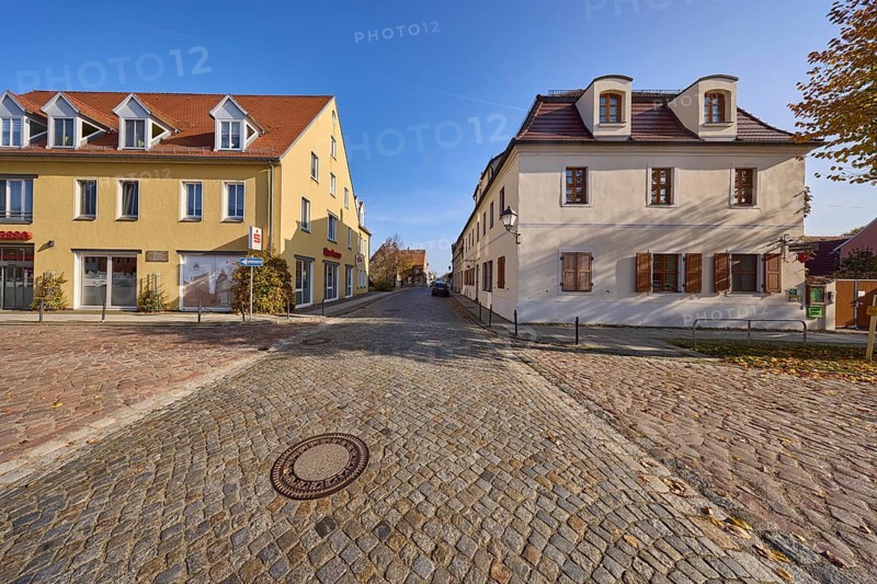 Village centre with residential buildings and cobblestone street, cloudless blue sky, intersection of Herrenstraße, Altstädter Markt and Lindenstraße, Mühlberg Elbe, Elbe-Elster district, Brandenburg, Germany