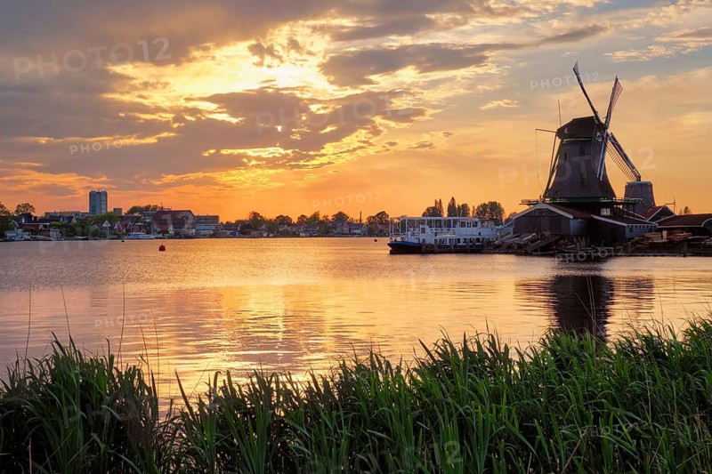Windmills at famous tourist site Zaanse Schans in Holland on sunset with dramatic sky. Zaandam, Netherlands