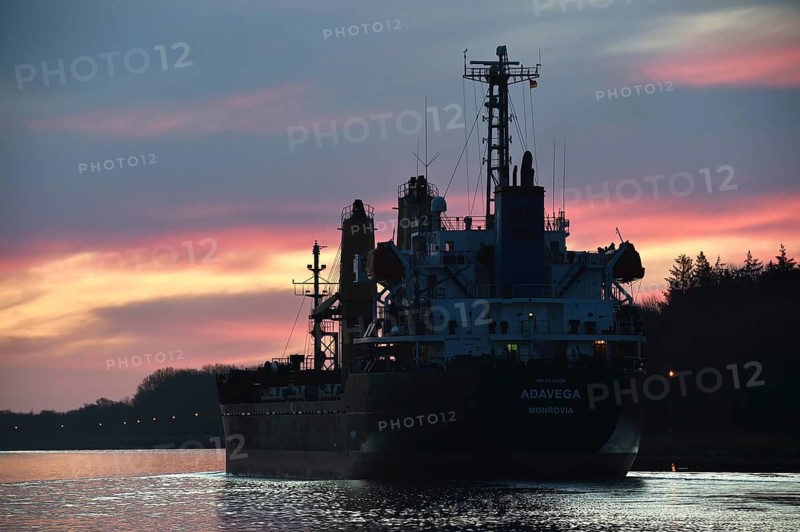 Cargo ship ADAVEGA sailing at sunrise in the Kiel Canal, NOK, Kiel Canal, Schleswig-Holstein, Germany