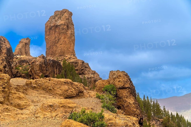 Volcanic rock formations of roque nublo dominating the landscape of gran canaria, spain, under a partially cloudy sky