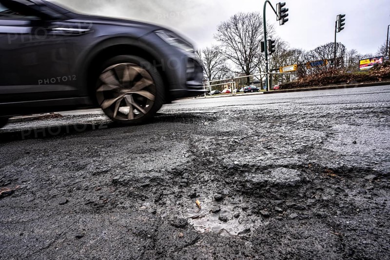 Large potholes at the confluence of Kruppstraße with Friedrichstraße, B224, heavy vehicle traffic, cars and trucks, as well as winter weather conditions have severely added to the road surface, Essen, North Rhine-Westphalia, Germany