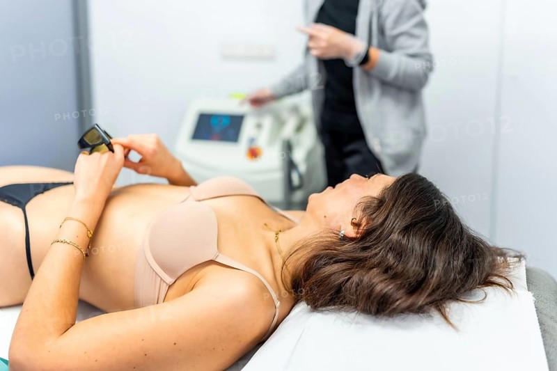 Woman lying on beautician clinic ready for hair removal treatment with modern laser technology