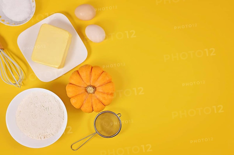Pumpkin pie ingredients and baking tools on yellow background with copy space