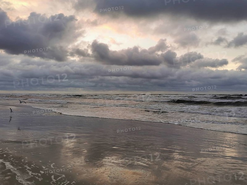 Waves reflect a partly cloudy sky when the sun rises or sets