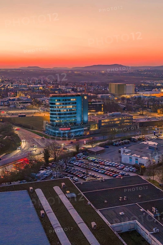 A high-rise building in the city at sunset with a pink sky, Porsche, Bietigheim, Germany