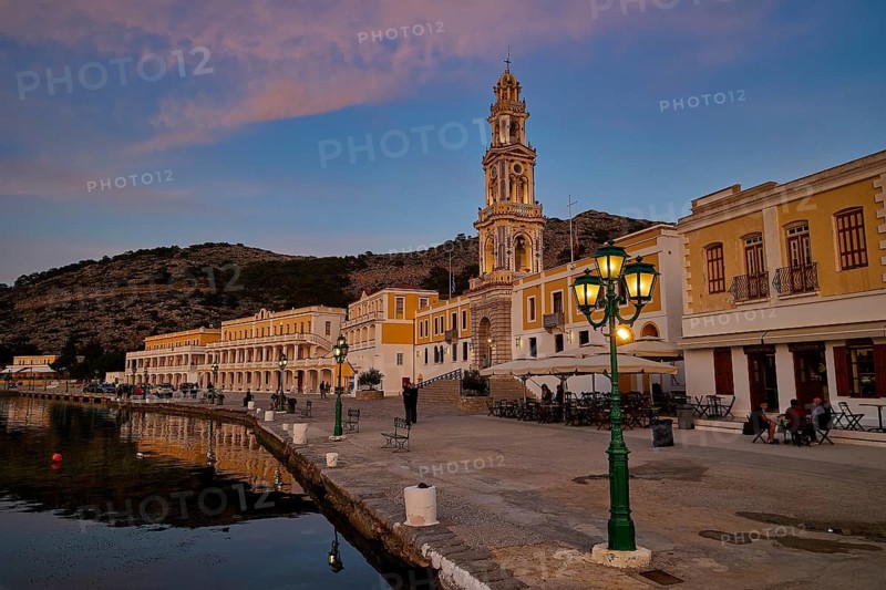 Coastal town view at dusk, illuminated buildings and harbour promenade, Holy Week, Bay of Panormitis, Panormitis Monastery, Symi, Dodecanese, Greek Islands, Greece