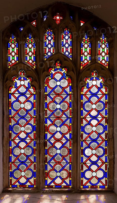 Stained glass window geometric red and blue pattern possibly by Henry Fiske, Middleton church, Suffolk, England, UK