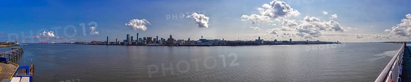 Panorama of a city by the river with blue sky and scattered clouds, Liverpool