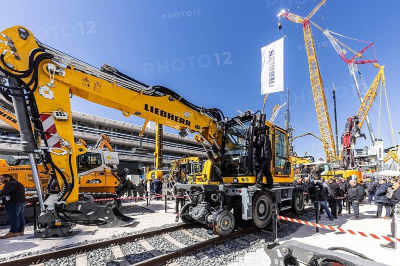 Road-rail vehicle for track construction. LG 1800-1.0 lattice boom crane with a maximum lifting height of 204 metres for wind turbines. BAUMA Munich, 34th World's Leading Trade Fair for Construction Machinery, Building Material Machines, Mining Machines, Construction Vehicles and Construction Equipment. In 2025, the trade fair will attract around 600, 000 visitors from more than 200 countries and regions and 3601 exhibitors. Open-air area with exhibits from Liebherr. Munich, Bavaria, Germany