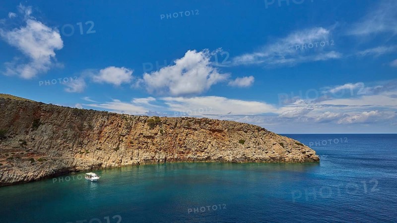 Menies, Rodopou, dream bay, single boat at anchor, pebble beach, crystal clear sea, green sea, turquoise sea, blue sea, Doric archaeological site, sanctuary of Diktynna, blue sky with white clouds, Rodopou peninsula, West Crete, island of Crete, Greece