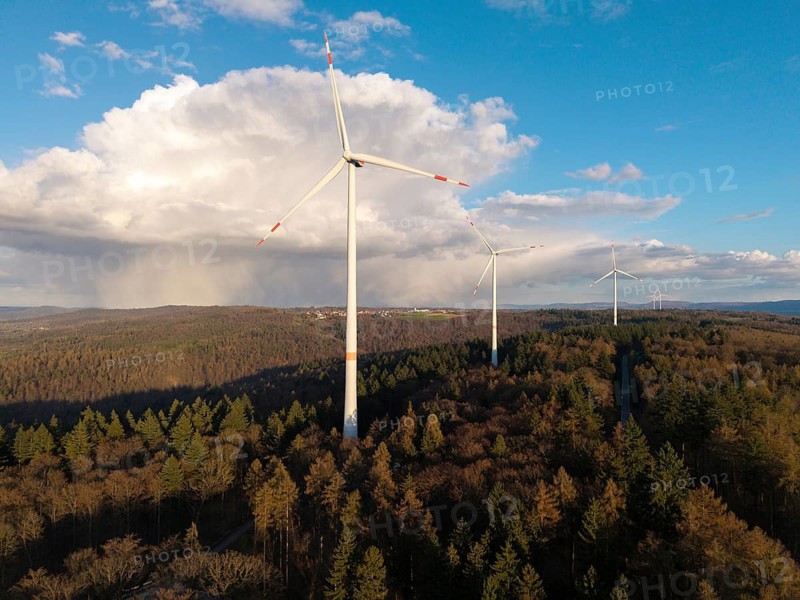 Large wind turbines over wooded hills under a partly cloudy sky, near Schorndorf-Winterbach, Baden-Württemberg, Germany