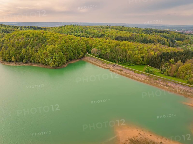A lake surrounded by forest in a hilly landscape with a tranquil atmosphere, Glems reservoir, Swabian Alb, Germany