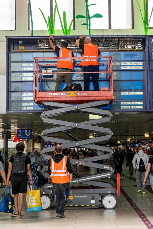 Technicians working on an electronic information board, display board for train connections at Düsseldorf Central Station, North Rhine-Westphalia, Germany