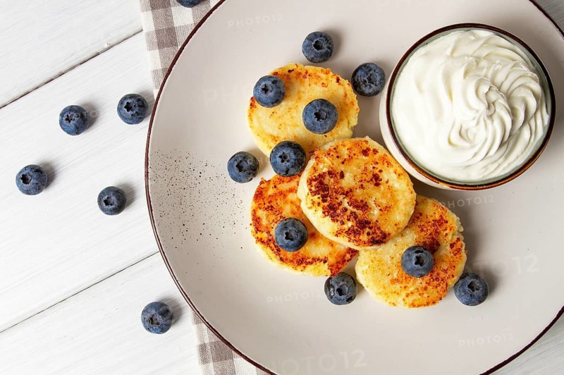 Cottage cheese pancakes, with blueberries, breakfast, on a white wooden table, no people, top view