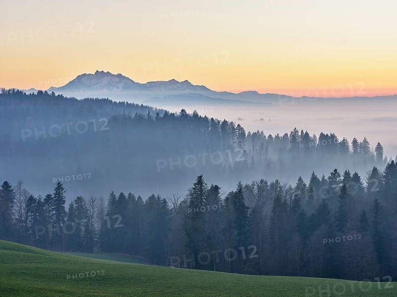 Foggy atmosphere in the light of the setting sun with a view of Mount Pilatus, Canton Zug, Switzerland