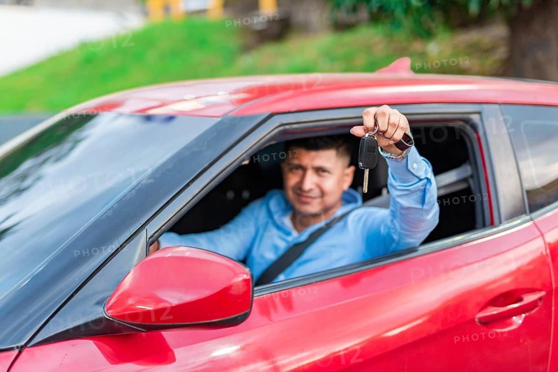 Male driver showing his car keys. Happy driver showing car key