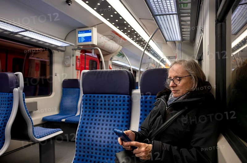 Elderly woman sitting in suburban train, train, operating mobile phone, smartphone, Stuttgart, Baden-Württemberg, Germany