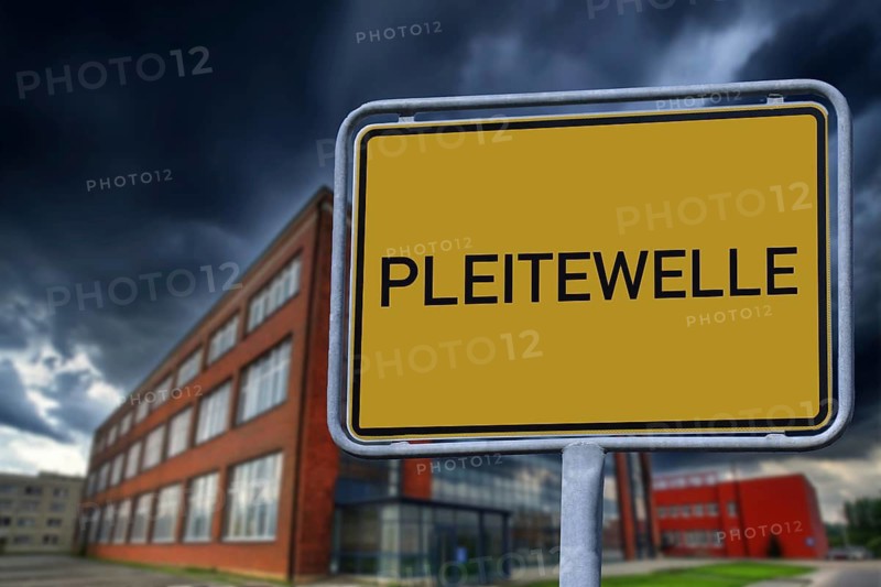 Symbolic image of insolvencies in Germany: Town entrance sign with the inscription PLEITEWELLE in front of a company building (Composing)