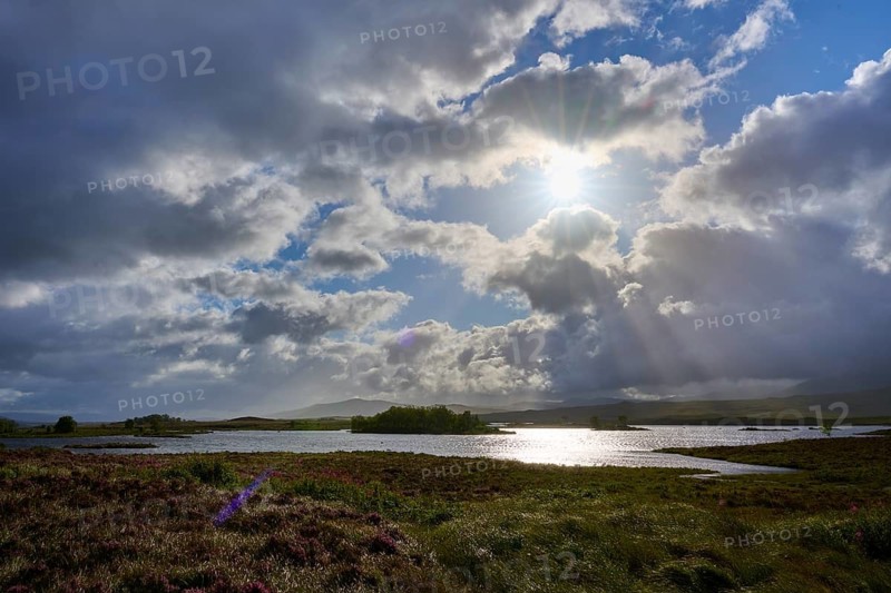 Reflecting lake under a sky with dramatic clouds and sun rays, Rannoch Moor, Bridge of Orchy, Scotland, United Kingdom, United Kingdom