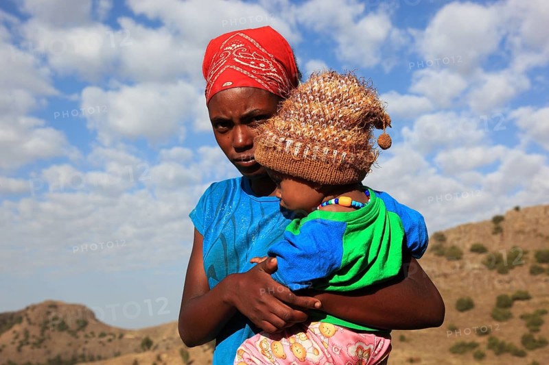 Young mother carries little boy in her arms, Ethiopia